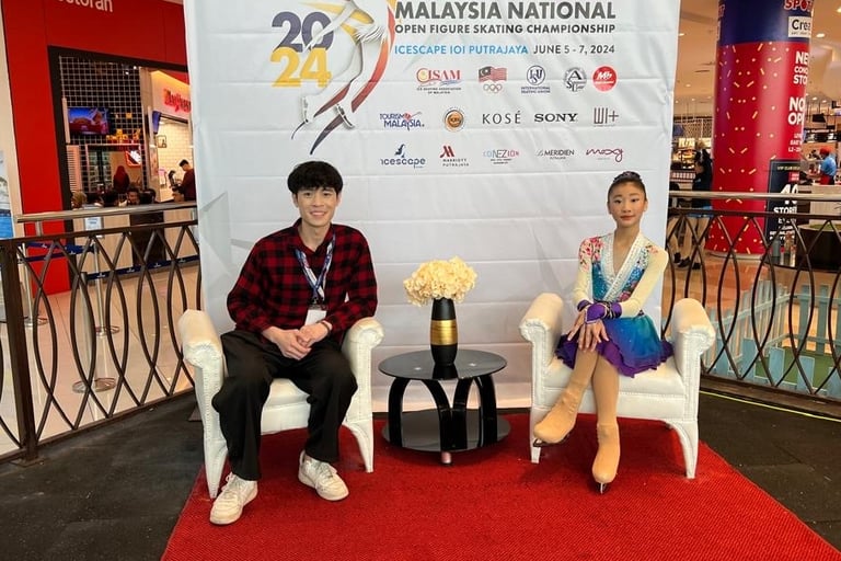 a man and woman sitting in chairs at a convention