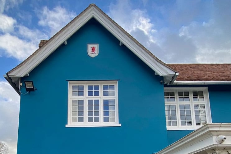 Frontal view on blue villa with red lion rampant in a painted white shield.