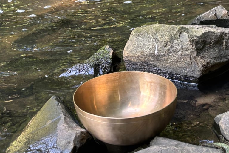 Klangschale steht behutsam am Wasser.