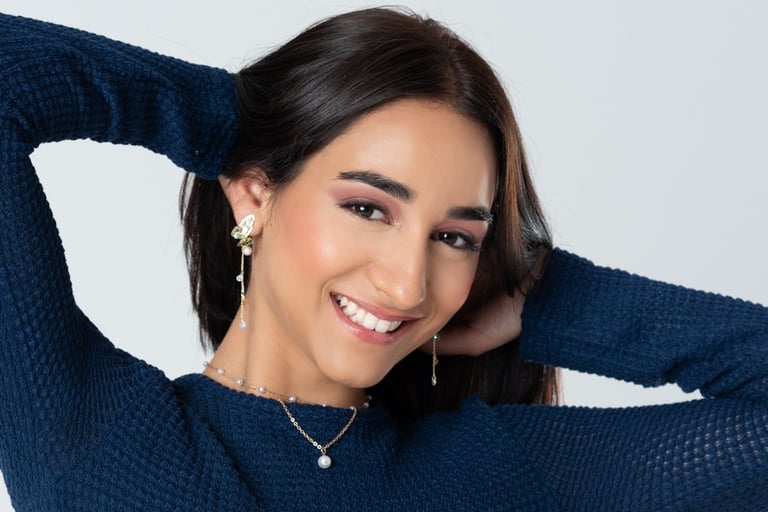 a woman in a blue sweater and a necklace with a necklace, retrato de estudio, quinceañera, retrato