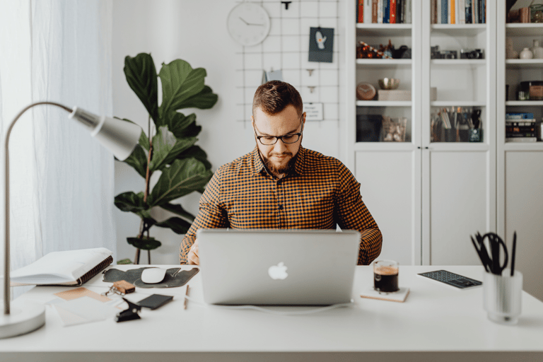 a man sitting at a desk with a laptop computer