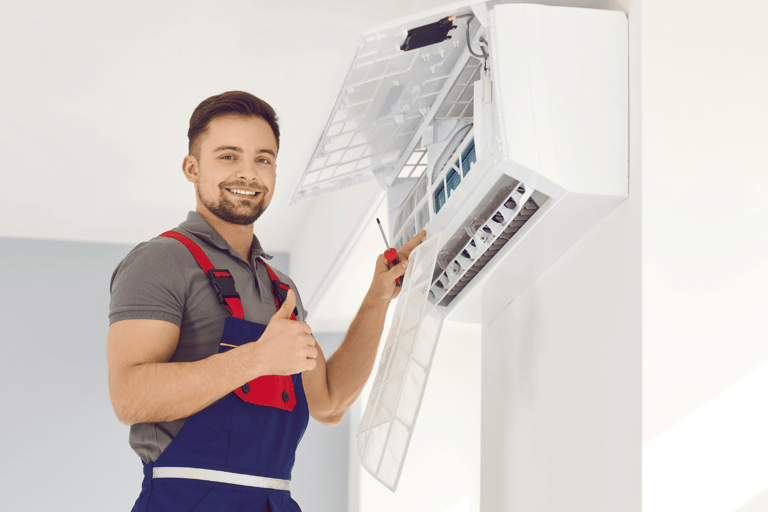 a man in overalls and overalls holding a large air conditioner
