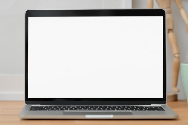 Laptop on desk with camera and mug
