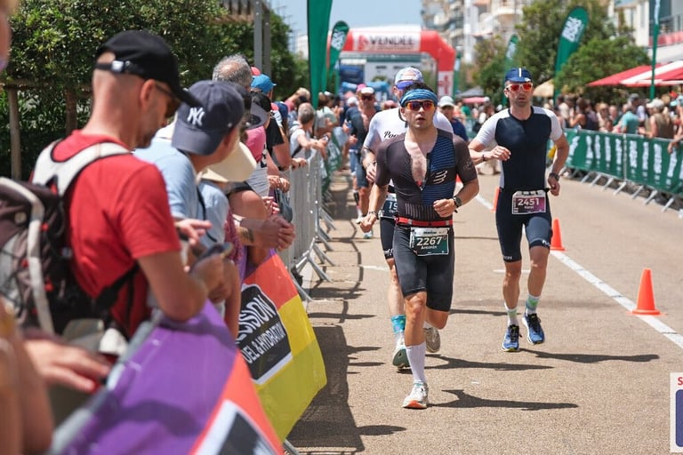 Un jeune homme court sur un triathlon format Ironman il porte des lunettes de soleil et un bandana