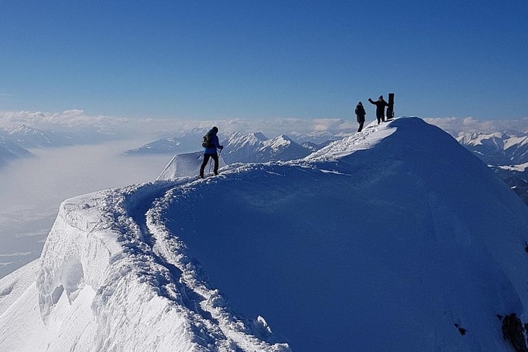 Führungskräfte erreichen gemeinsam den Gipfel – Symbol für Klarheit, Fokus und Teamresilienz