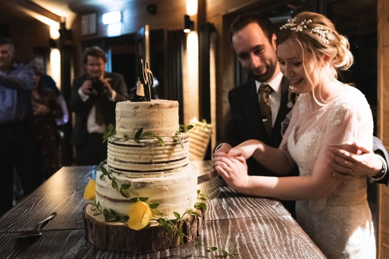 a bride and groom cutting their wedding cake