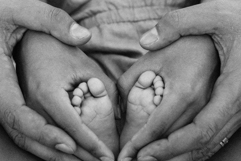Parents holding babies feet in a heart shape