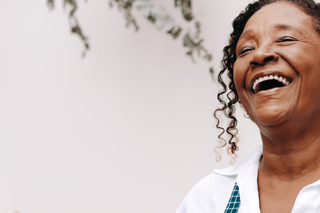 senho sorrindo utilizando aparelhos auditivos