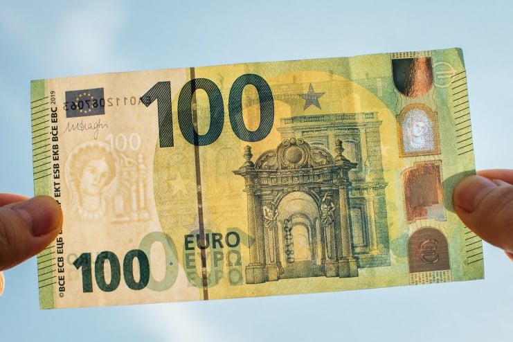 a person holding a bank note with a 100, 000 note note