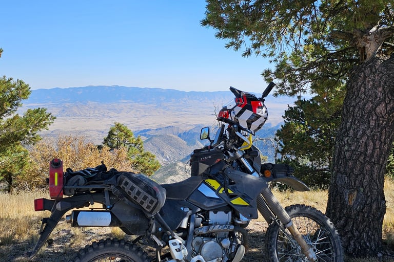 a motorcycle parked on a dirt road near a tree
