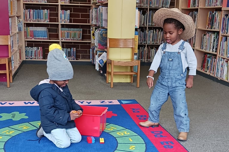two children interacting in a library, playing on kids carpet