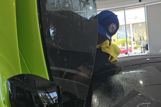 bluemax Technician intalling window film on a mclaren windows