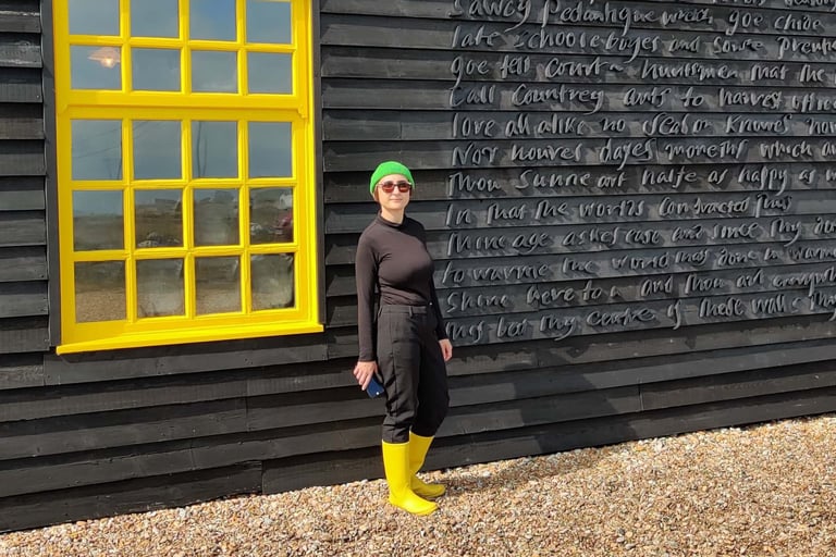 photo of Micha wearing bright yellow welly boots next to yellow window