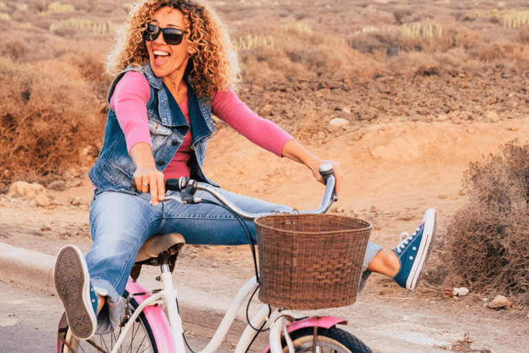 Smiling woman riding a bicycle enjoying freedom from pelvic pain