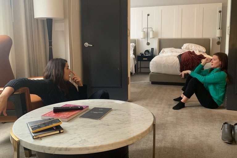 Image of two women talking seriously in a hotel room.