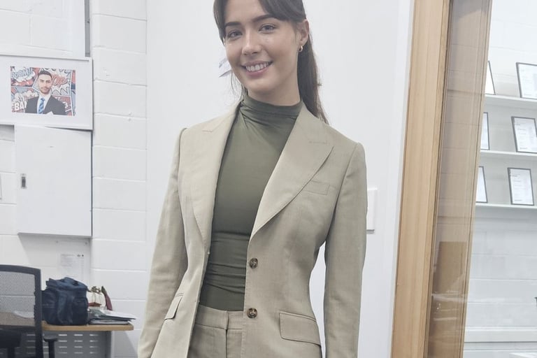 a woman in a suit and heels standing in a room