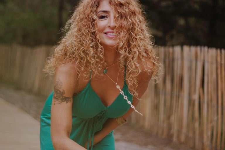 a woman in a green dress and a wooden fence