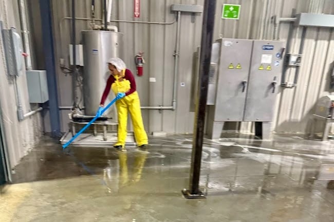 CLEANING SPECIALIST DEEP CLEANS THE FLOOR AT AN INDUSTRIAL FACILITY