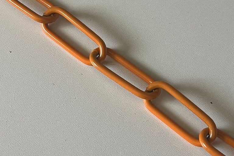 Runder Kreis mit einem Farbmuster mittig eine Kette in Orange, Hundekette, Pulverbeschichtet