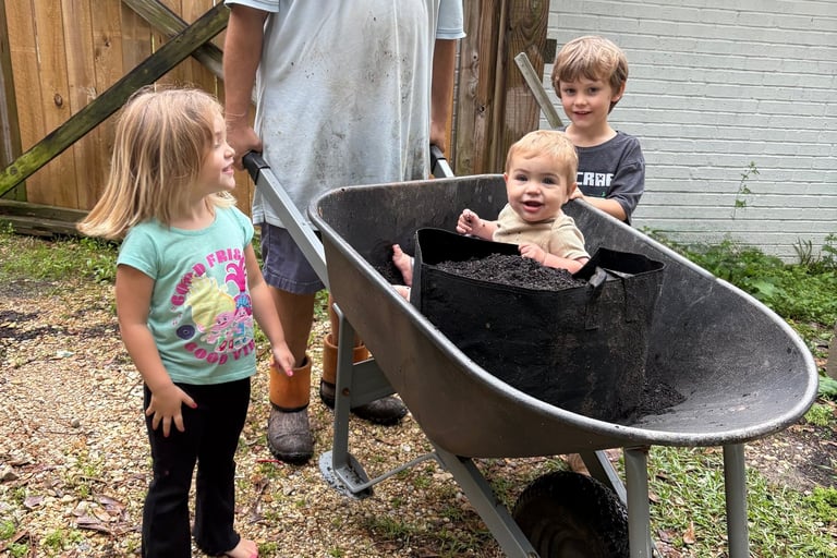 a man and three children in a wheelbarrow