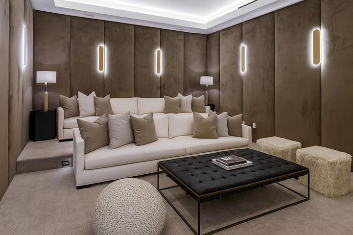 Luxurious home theater with custom wall panels, plush sofa, modern lighting, and stylish coffee table by Solo Home Decor.