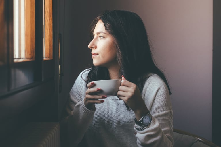 Woman, sips tea calmly, feeling relief from nerve pain and tingling in her hands