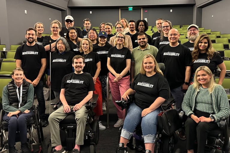 The Microsoft accessibility team in an auditorium, Sean seated at front with other wheelchair users
