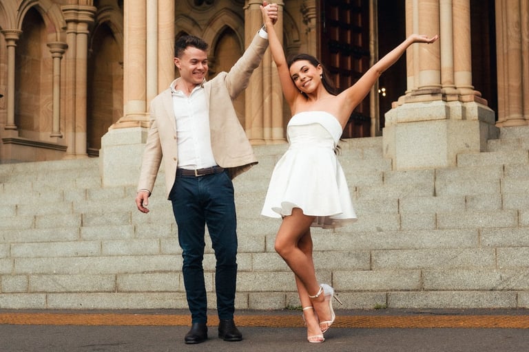 a man and woman dancing in front of a building