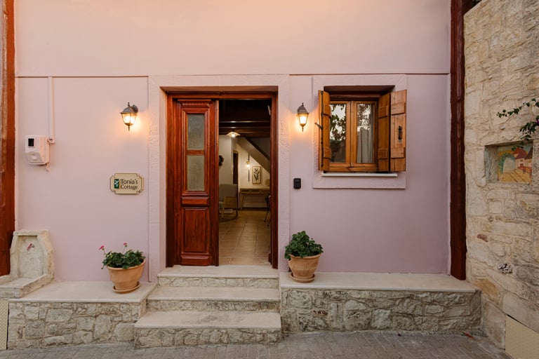 Tonia's Cottage entrance door open, logo sign and purple flowers