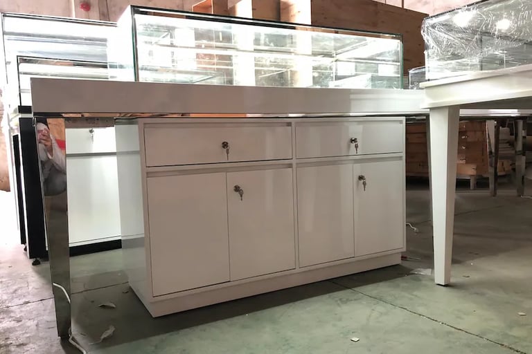 Modern white jewelry display counter with glass showcase and locking storage cabinets for retail stores.