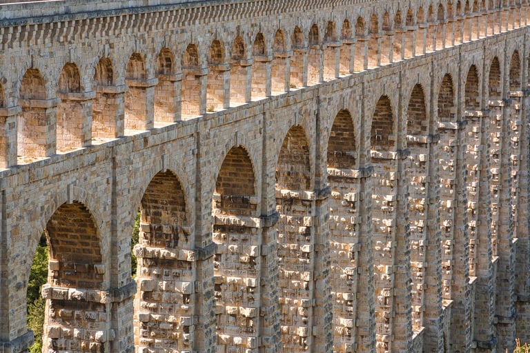 Ancient aqueduct bridge with stone arches, showcasing historic masonry and architectural engineering.