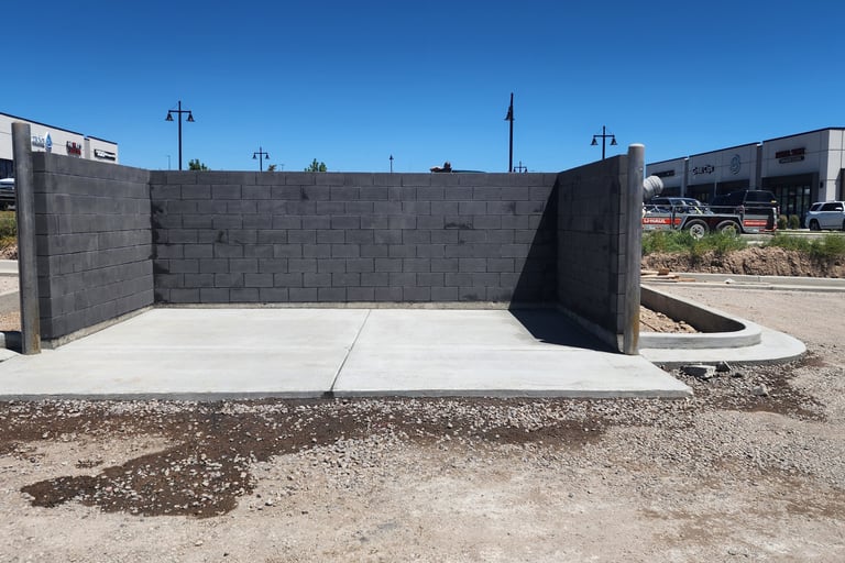 Charcoal colored CMU trash enclosure with precast concrete cap