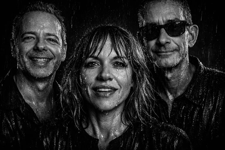 Black and white portrait of a smiling Rockadelic band standing in the pouring rain.