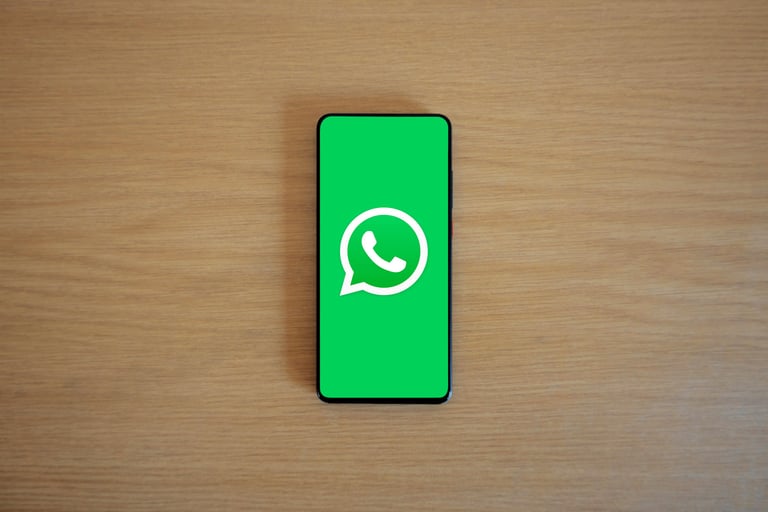 Un teléfono inteligente sobre una mesa de madera que muestra el logotipo de la aplicación de mensaje