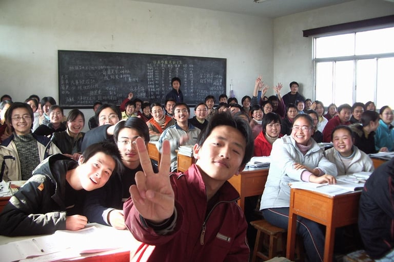 classroom of students, smiling, one is giving a peace sign