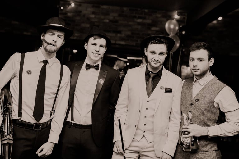 four men dressed in 1920s outfits at a murder mystery.