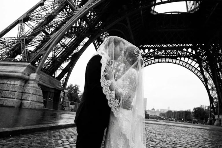Pareja de novios casados bajo la estructura de la Torre Eiffel en París, fotografía artística