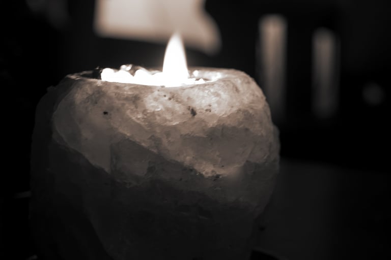 Lit candle in a rough crystal holder with soft light in a dark setting