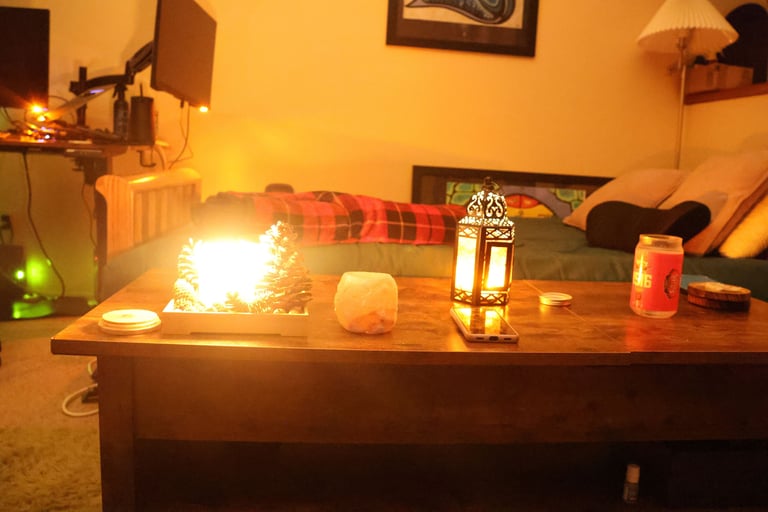 Low light candlelit living room with candles glowing on a wooden table and a sofa in the background.