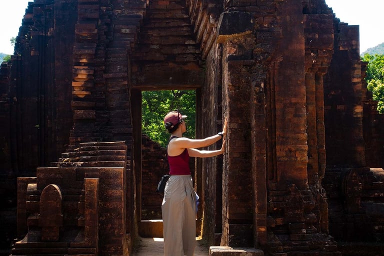 person touching temple wall inside my son sanctuary ruins vietnam