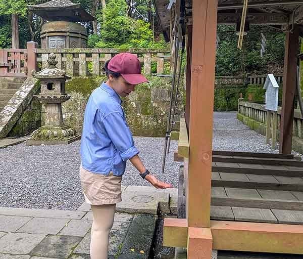 Traveler performing the purification ritual at a Japanese shrine.