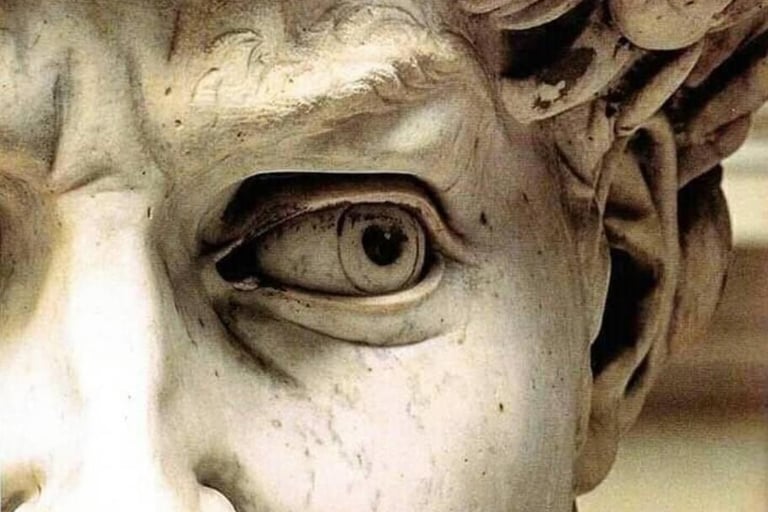 Extreme close-up of Michelangelo's David statue showing detailed eye, brow, and marble texture.