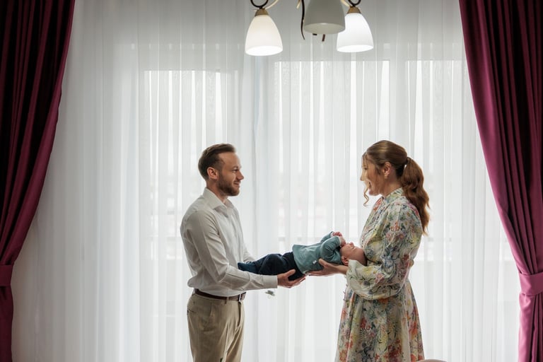 Fotograf botez Oradea – portret de familie cu bebeluș în studio, părinți tineri surprinși într-un mo