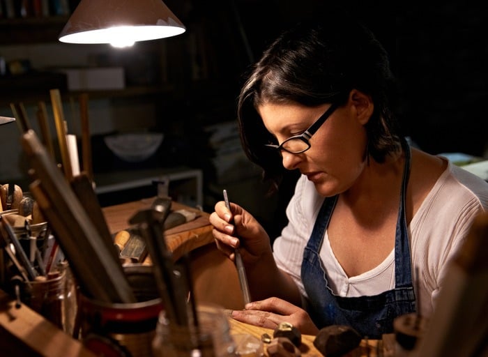 Un joyero creando collares y pulseras artesanales con cuentas en un espacio de trabajo