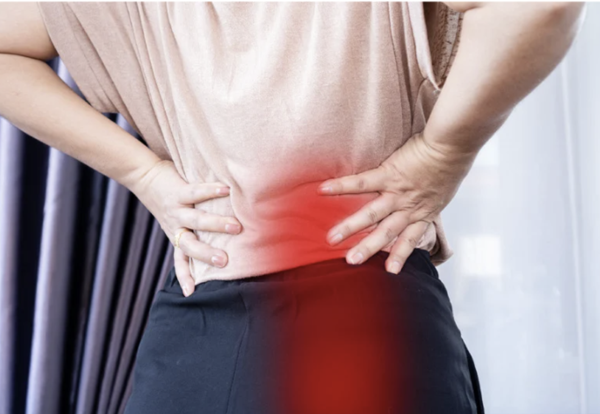 A person holding their lower back and hip due to chronic muscle pain and sciatica.