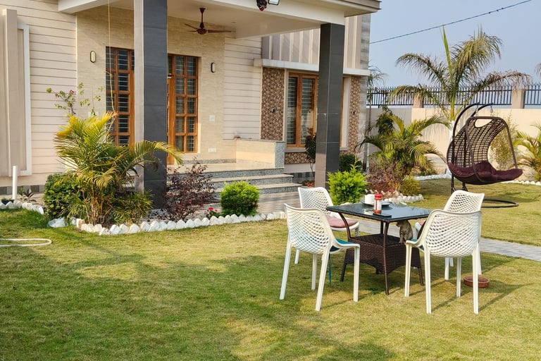 Modern luxury PG featuring a green lawn with a patio set and a second-story balcony.