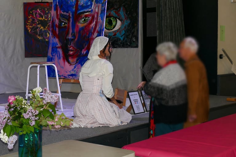 Artiste en interaction avec le public sur scène lors d'une exposition, entourée de grandes peintures