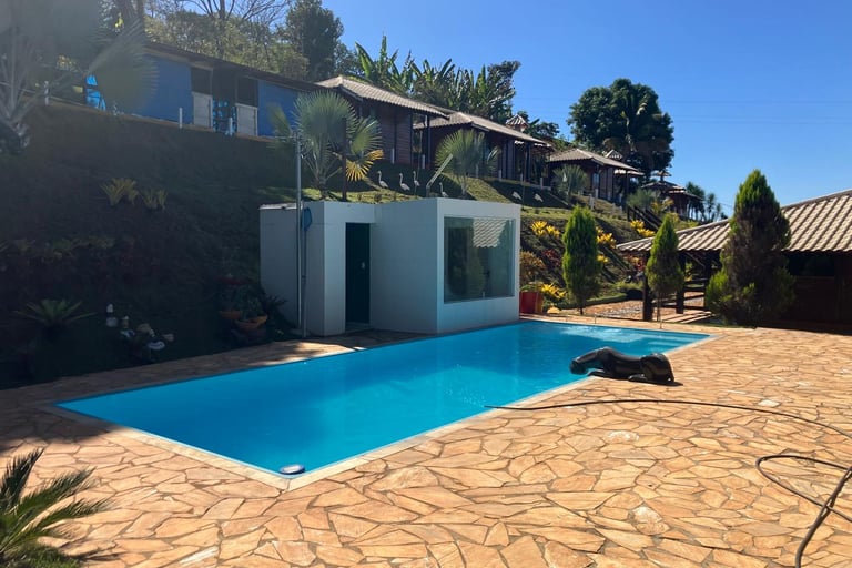 Luxury outdoor swimming pool at a hillside resort with blue water and stone patio.
