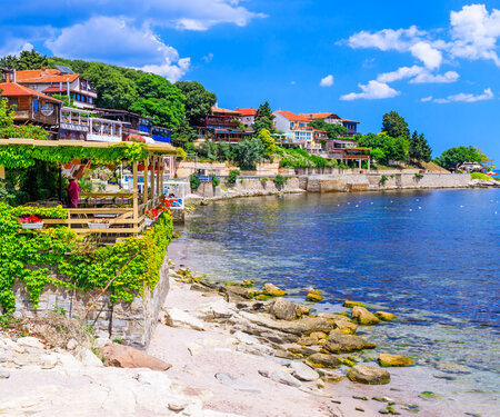Scenic seaside view of Nessebar Old Town in Bulgaria with waterfront restaurants and blue Black Sea coast.