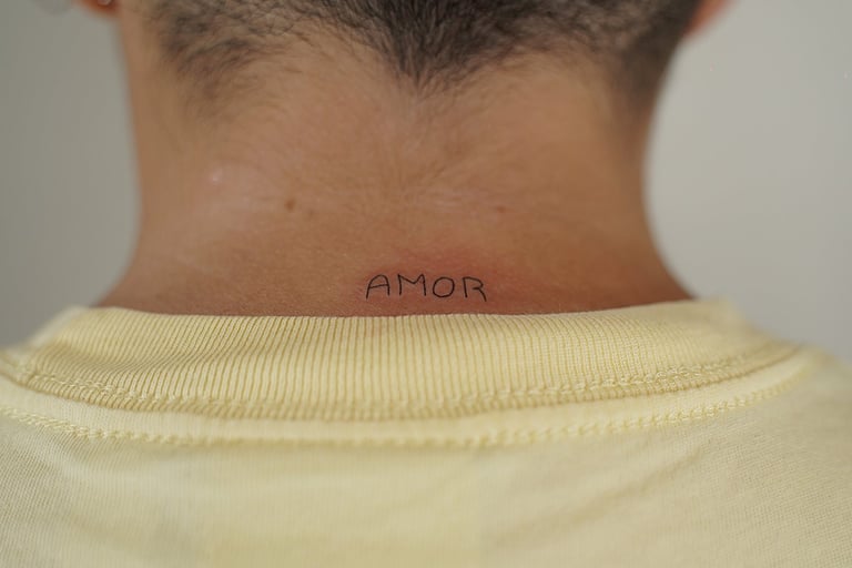 Tatuaje fineline en Madrid con lettering AMOR en mayúsculas en la nuca